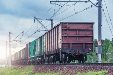 Yük treni gün batımında bahar ormanından geçer..