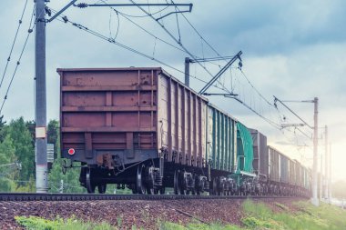 Yük treni gün batımında bahar ormanından geçer..
