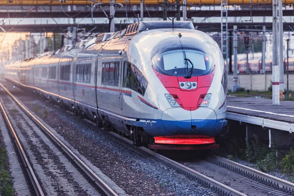 Comboio de alta velocidade move-se para São Petersburgo ao pôr do sol . — Fotografia de Stock