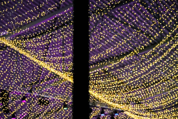 Weihnachtsbeleuchtung, Dekoration des Daches des Einkaufszentrums. Flieder und gelbe Lichter — Stockfoto