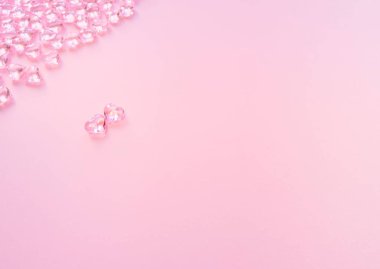 Kalp şeklinde elementler pastel pembe arka planda uçuyor. Sevgililer Günü için zarif bir kompozisyon. Mutlu kadınların, annelerin, sevgililer gününün aşk sembolleri. Düz konum, üst görünüm, kopyalama alanı, yasaklama