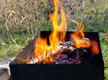 Burning wood and coal in a barbecue. Luminous coals in a grill for a barbecue in the open air, outdoors. clipart