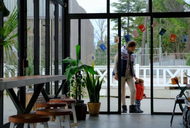 Çekici anne ve tatlı bebeği bir kafede dinleniyorlar. Aile tatili. Kafede çocuklu güzel bir kadın. Aile Kafesi.