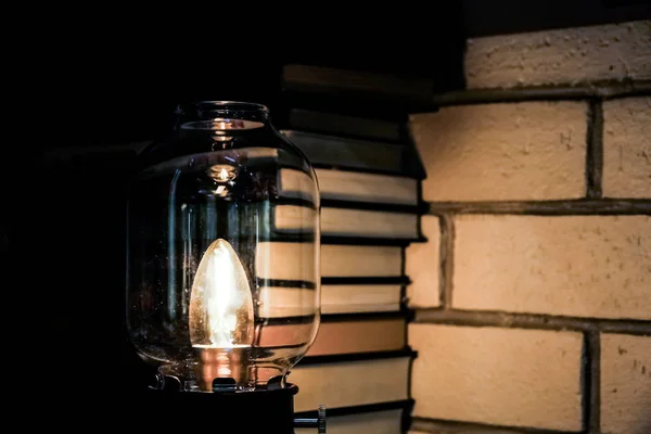전기등을 켜는 것은 책 과 벽돌 건초 배수구 옆에 있다. 독서. 지식에 대한 갈망. 역으로 — 스톡 사진