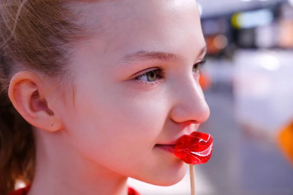 Girl kisses a lip shaped lollipop