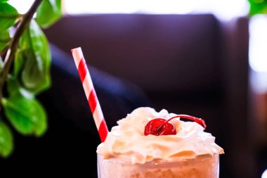 Koyu arkaplanda kremalı ve kirazlı milkshake