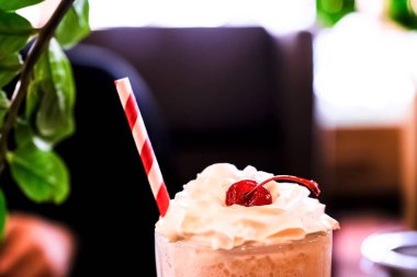 Koyu arkaplanda kremalı ve kirazlı milkshake