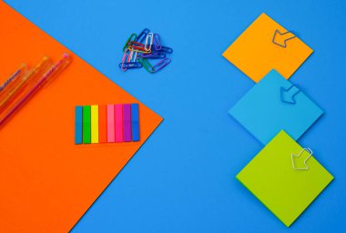 Mavi monofonik arka planda renkli bir kırtasiye. Model, mesaj için yer aç. İş, eğitim. Takas.