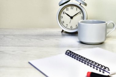 Business. Workplace. Alarm clock, notepad and cup of coffee