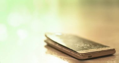 Mermer arka planında çatlak çizikler olan kırık ekran altın renkli cep telefonu. Bozuk cep telefonu görüntüsü. Fotoğrafçılığı kapat