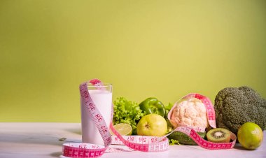 Çevreyi ölçmek için şerit çekiliyor. Diyet pişirmek için sebzeler. Zayıflama