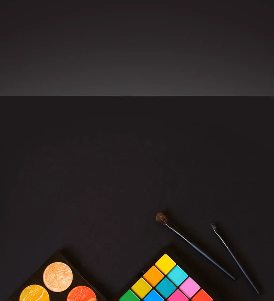 鮮やかで多色の色合いのパレットと黒の背景にハイライトのパレット メイクブラシ モックアップ コピースペース — ストック写真