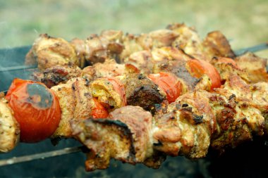 Barbekü. Izgaradaki kömürde ızgara ızgara. Domates, soğan ve biberle yakın çekim. Barbekü kampı yemeği..