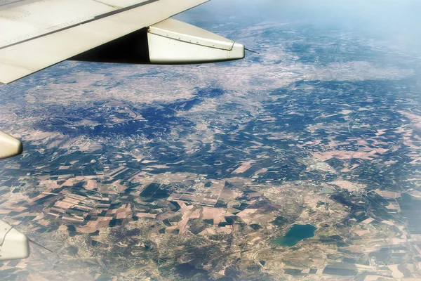 Blick von oben auf den Boden aus dem Flugzeug. Europäische Landschaft. bunte Muster von Bäumen, Feldern, Flüssen und Seen. — Stockfoto