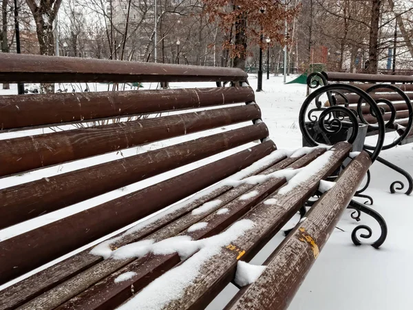 Bancs rouges dans un parc recouvert de neige — Photo