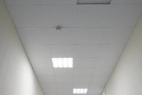 停止グリッド正方形の形のケイ酸カルシウムボードを使用してオフィスやキッチンの屋根の偽の天井のインテリアビューやデザイン 要旨オフィスライト付きの空の白いインテリア空間 コピースペース — ストック写真