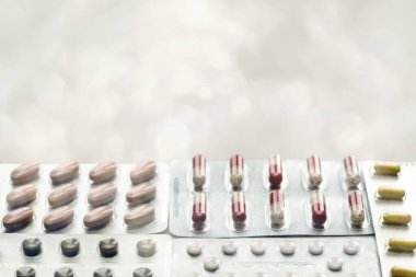 Vitaminler ve tabletler su toplamış, yakın plan. Bulanık arkaplan, metin eklenecek yer. Modern sağlık ve eczane.