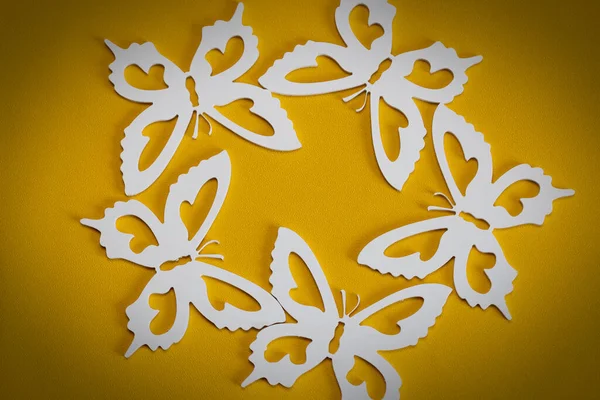 The concept of nature in spring. Minimal flatley composition, top view. White butterflies on a yellow background, a creative minimal concept, copy space.