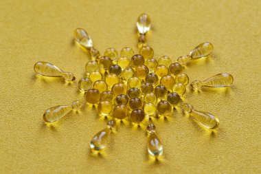 İlaç hapları, parlak sarı arka planda D vitamini içeren kapsüller. Metnin için yerin bir kopyası. Tıp kavramı. Minimalist soyut kavram. Neon sarısı