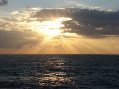 Günbatımından önce sakin tropik deniz ve güneş. Doğal manzara arka planı