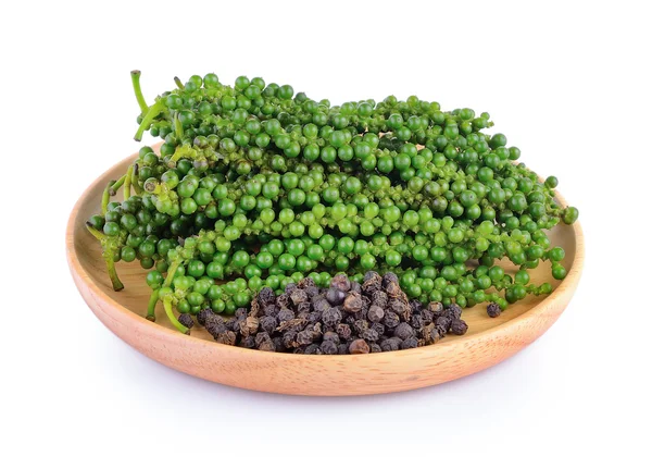 Pimienta en plato de madera sobre fondo blanco — Foto de Stock