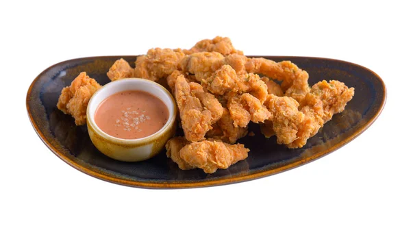Жареная курица с соусом в тарелке на белом фоне — стоковое фото