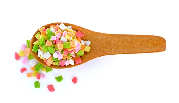 Caramelo colorido en cuchara de madera sobre fondo blanco — Foto de Stock