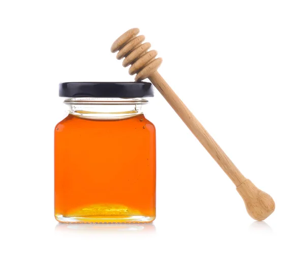 Honey with wooden honey dipper on jar Royalty Free Stock Images