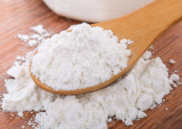 Pile of white wheat flour in wooden spoon — Stock Photo, Image