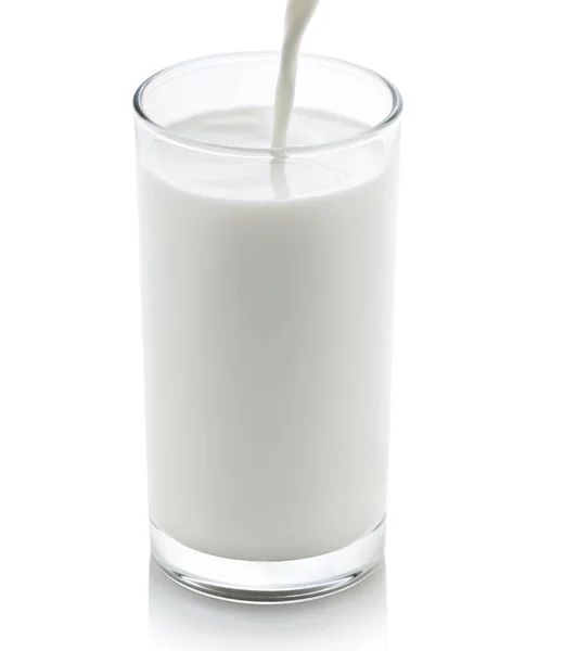 Γάλα Που Ρίχνει Από Μια Κανάτα Ένα Ποτήρι Λευκό Φόντο — Φωτογραφία Αρχείου