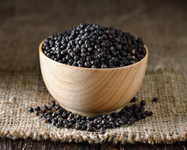 Black pepper in wood bowl — Stock Photo, Image