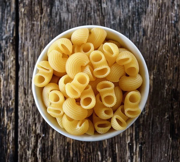 Macaroni in kom op hout — Stockfoto