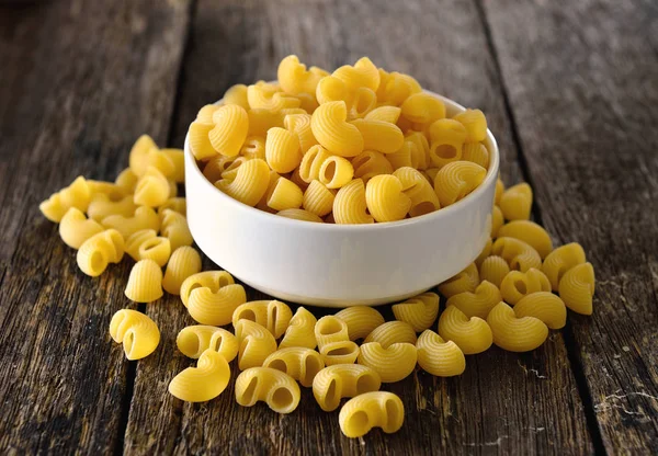 Macaroni in kom op hout — Stockfoto
