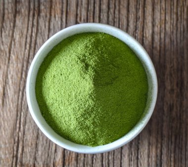 Yeşil çay tozu Kupası ahşap masa üzerinde