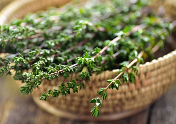 Thyme herb in basket on wooden table. — Stock Photo, Image