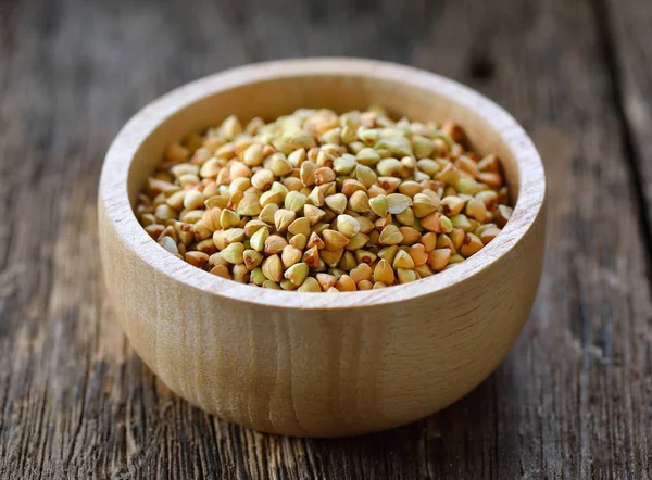 Buckwheat in wood bowl on table — Stock Photo, Image