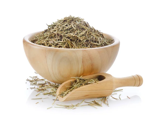 Dried rosemary leaves in wooden bowl over white background Royalty Free Stock Images