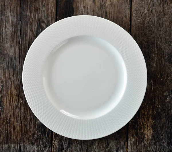 Άσπρο πιάτο σε ξύλινα — Φωτογραφία Αρχείου