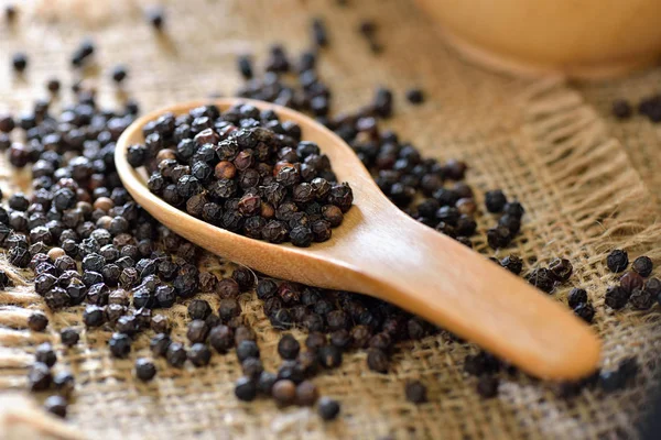 Black pepper in wood spoon — Stock Photo, Image