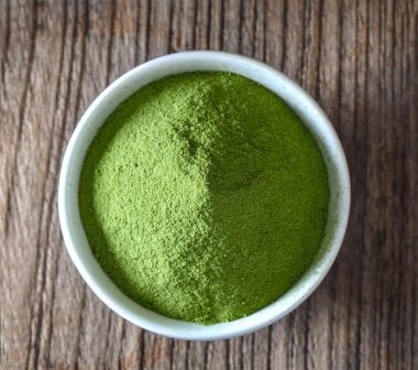 Yeşil çay tozu Kupası ahşap masa üzerinde