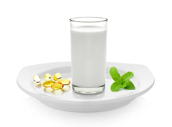 Glass of milk mint and fish oil  on white plate — Stock Photo, Image