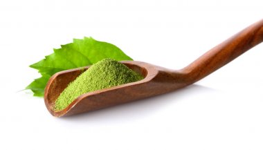 Beyaz arka plan üzerinde Kepçe yeşil çay tozu