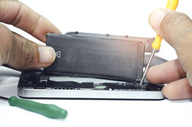 Stüdyo beyaz arka planda çalışan teknisyenlerin akıllı telefon için ana karta akü yüklemesi