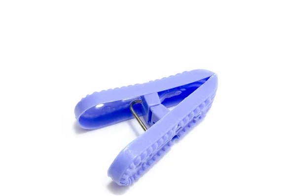 Beyaz arkaplanda tek mavi plastik mandal.