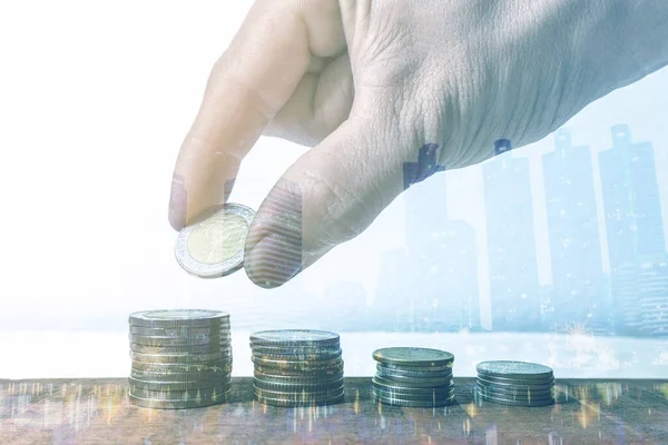 Şehir arka planının çifte pozlandırılması. Elle para biriktirme ile finans ve bankacılık konsepti yumuşak bulanıklık üzerine