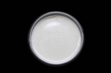 En üstteki görüntüde bir bardak taze süt. Siyah arka plana yerleştirilmiş. İçmeye hazır.