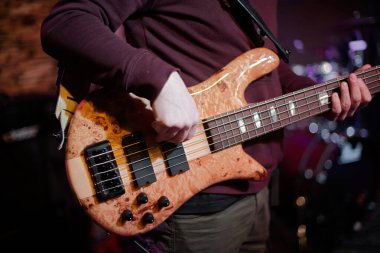 Rock grubu sahnede çalıyor. Gitarist, bas gitar ve bateri. Gitarist çalıyor..