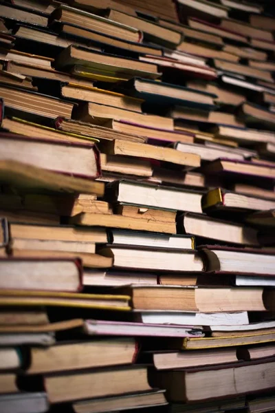 Una gran pila de diferentes libros en la biblioteca. Una biblioteca llena de libros. Lectura. Un gran número de libros de diferentes géneros y tamaños. Estudiar y educar. Conocimiento . —  Fotos de Stock