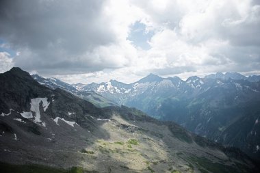 Güneşli bir baharda, dağların altında taze yeşil çayırlarda otlayan ineklerle dolu güzel panoramik manzara, Ulusal Park Hohe Tauern, Salzburger Land, Avusturya