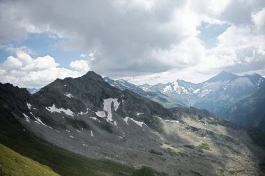 Güneşli bir baharda, dağların altında taze yeşil çayırlarda otlayan ineklerle dolu güzel panoramik manzara, Ulusal Park Hohe Tauern, Salzburger Land, Avusturya